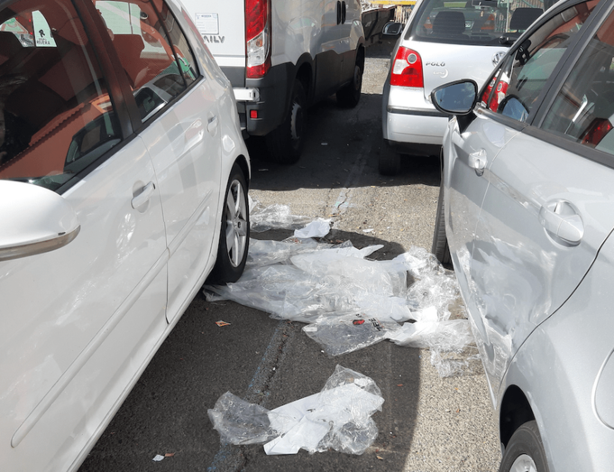 Varios plásticos entre coches en el aparcamiento del Mercado Municipal (Foto TA)